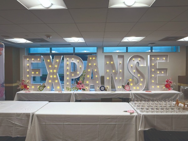 a black letter three dimensional LED sign that says "EXPANSE"