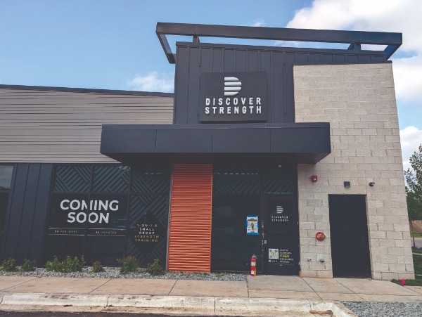 a storefront with a sign that reads "Discover Strength"