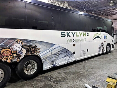 White bus with custom vehicle wrap Photo