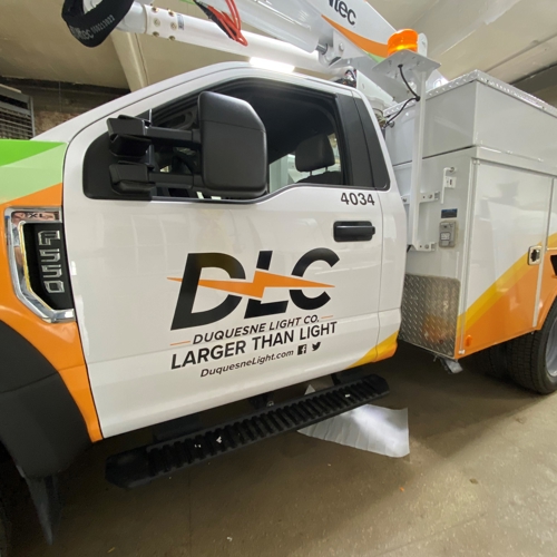 White truck with vehicle wrap
