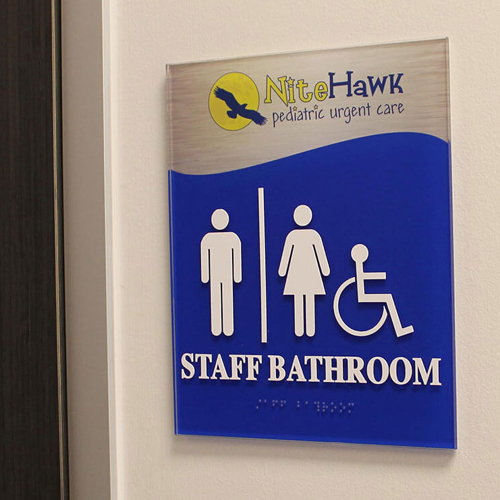 blue bathroom regulatory sign with braille