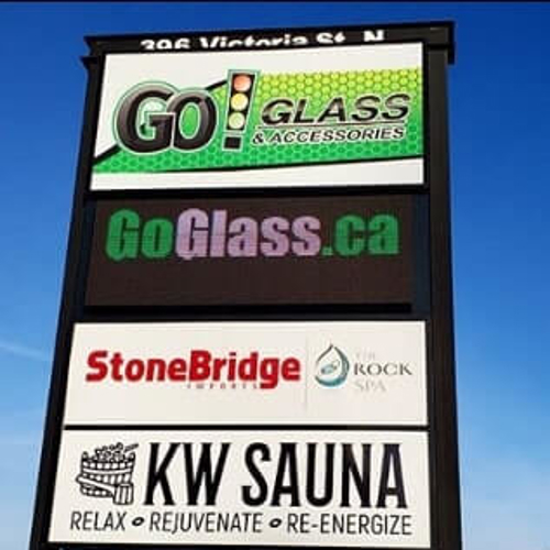 Pylon sign with different business names on the side of the road