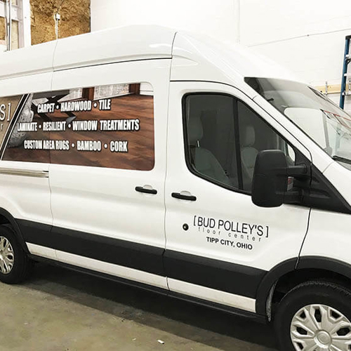 White Van with Bud Polley's graphics parked on a garage