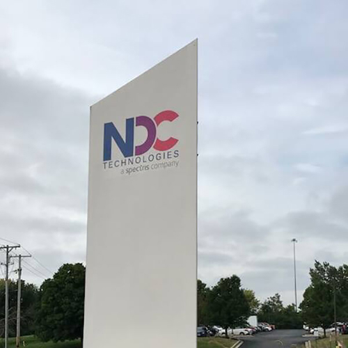 NDC exterior signage on the side of the road surrounded by plants