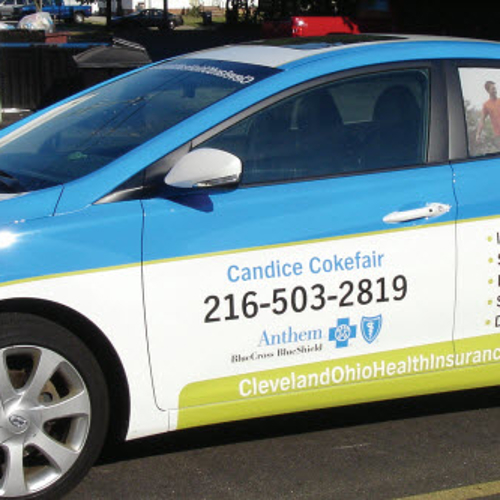 Car wrapped with graphics parked on a lot