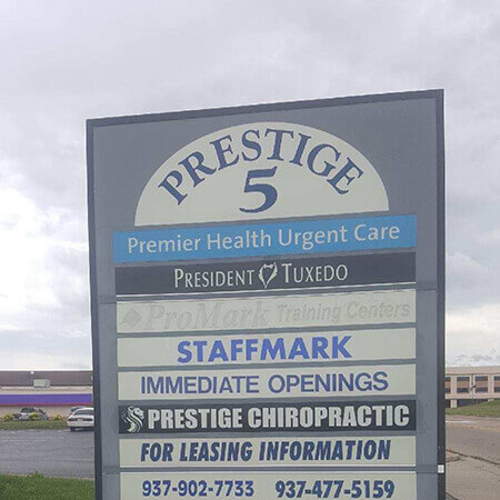 Prestige 5 Wayfind Signs by the side of the road with car and building on the back