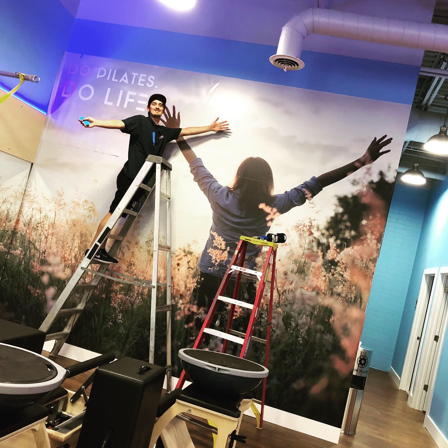A FASTSIGNS team member posing in front of a recently completed sign during sign installation services
