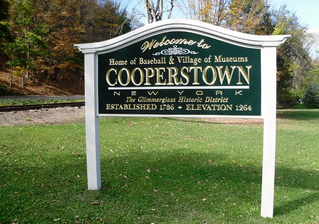 A sign in the grass introduces guests to Cooperstown