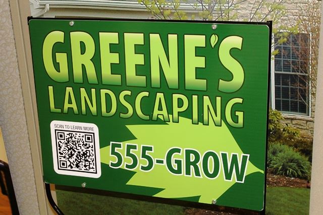 A sign for landscaping services featuring a QR code