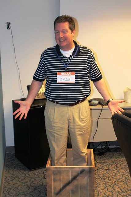 An employee stands in a box while wearing a nametag that says Jack