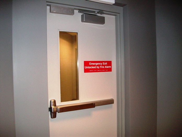 A door has an emergency exit sign on it