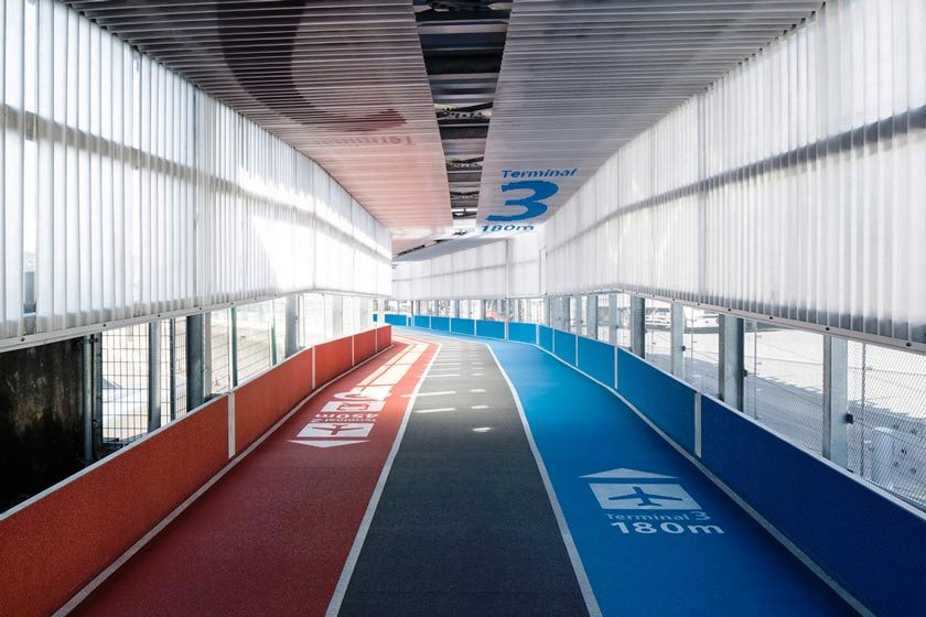 A walkway at an airport uses floor graphics to guide travelers to their destination