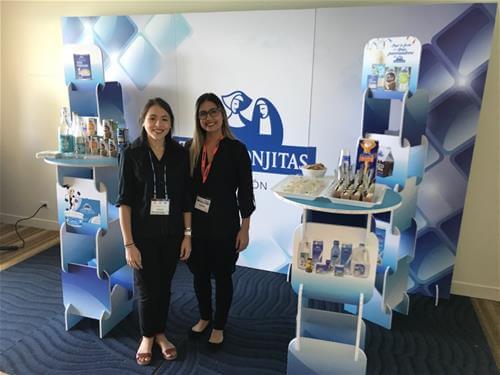 2 women standing near product at trade show 