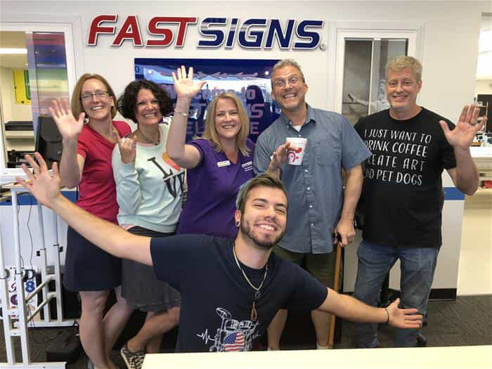 The team of FASTSIGNS Snellville poses together inside their store
