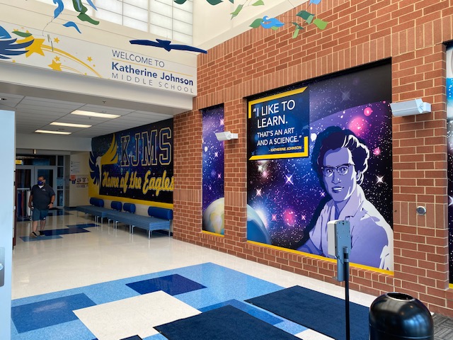inside of a middle school with a space themed mural on the wall