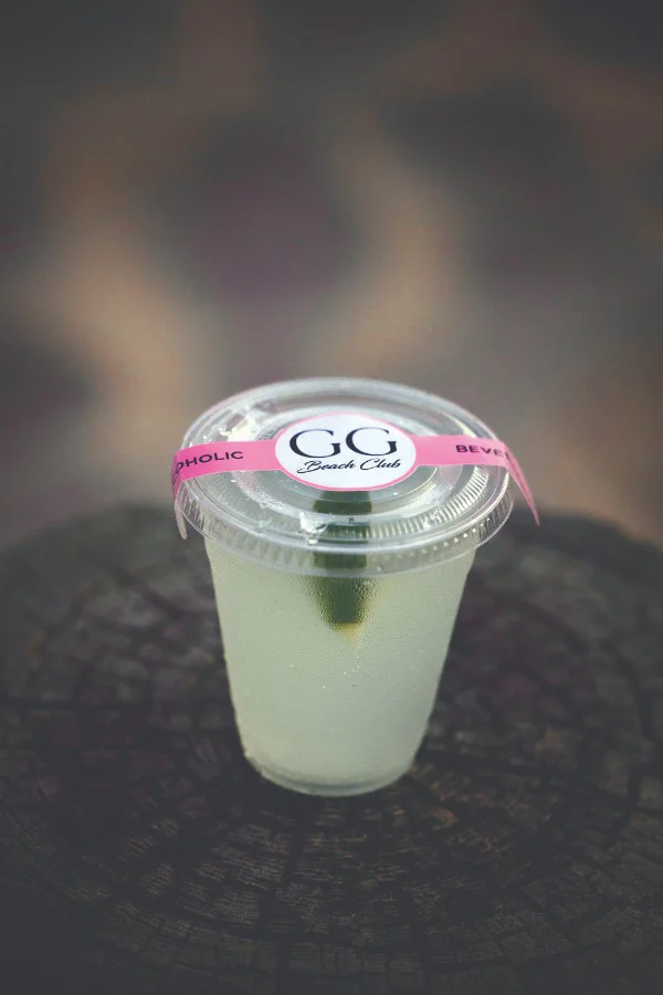 a plastic cup with a pink label on top