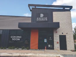 a storefront with a sign that reads "Discover Strength"