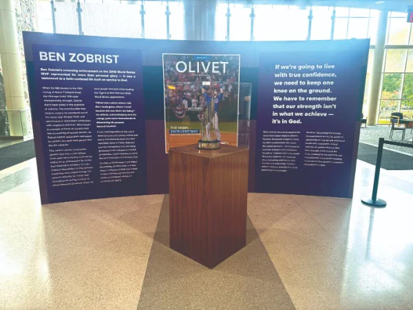 a trophy on a stand with a tri-fold sign behind it
