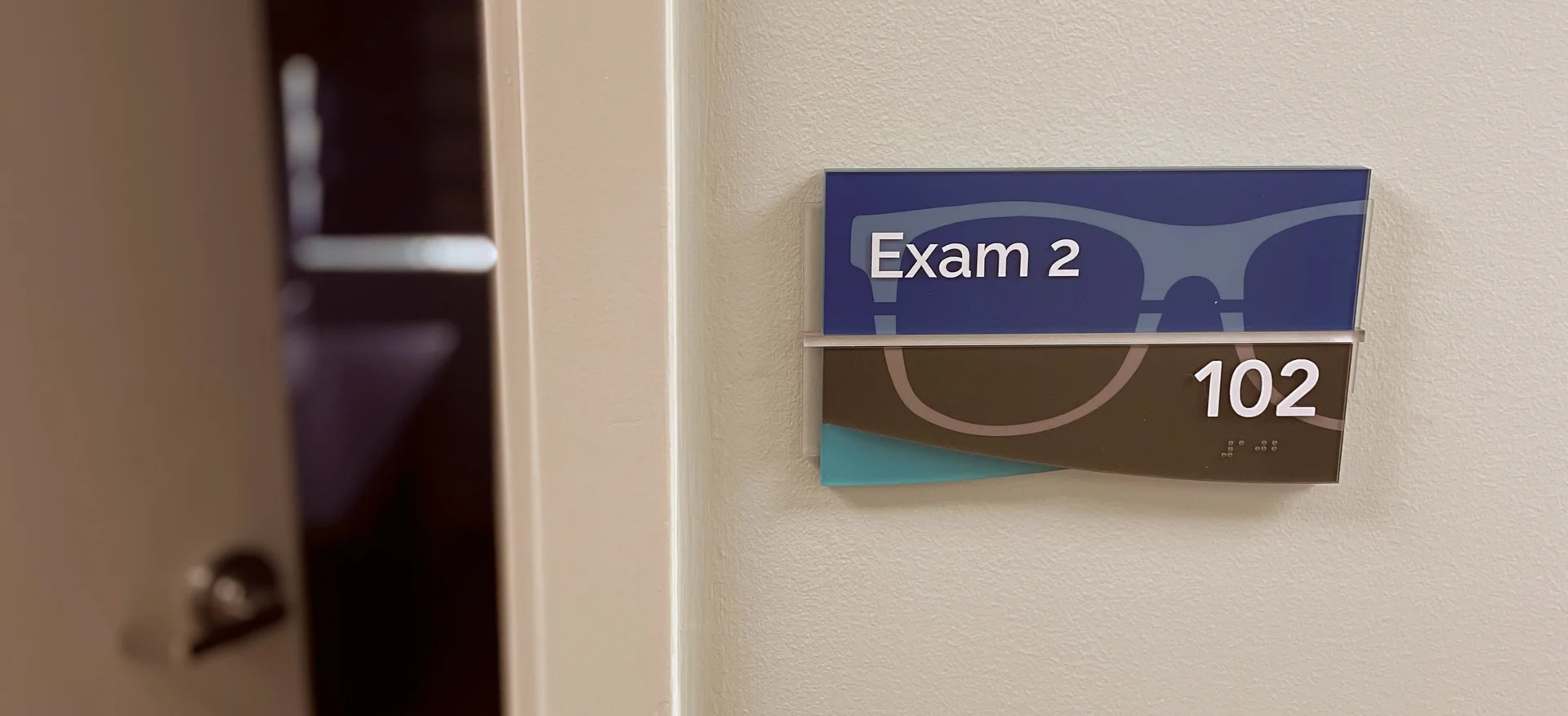 ADA compliant medical signage displaying the room number in a healthcare facility setting