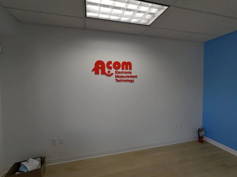 An image of the A.COM Electronic Measurement Technology interior dimensional letters in red.
