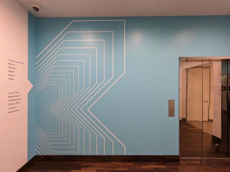 An image of the blue and white floor to ceiling wall graphics that includes an adjacent wall graphic with text.