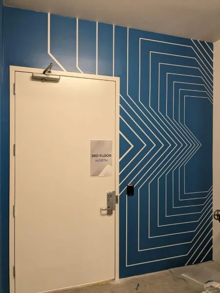 An image of the dark blue and white floor to ceiling wall graphics around a door.