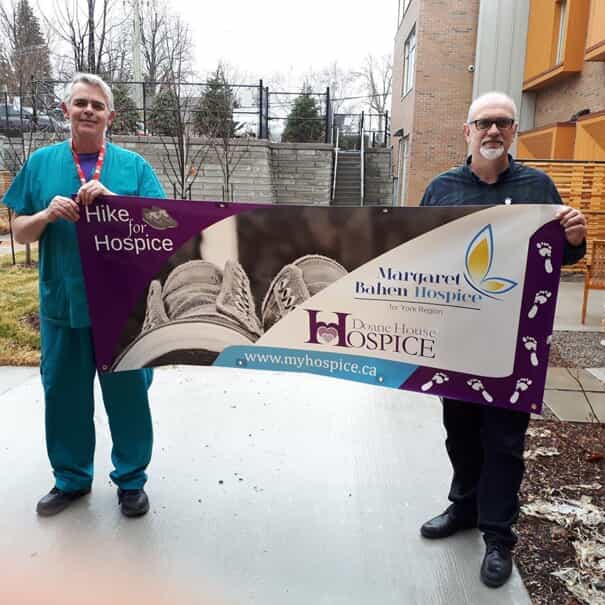 FASTSIGNS of newmarket employees hold up a banner that was donated to Margaret Bahen Hospice