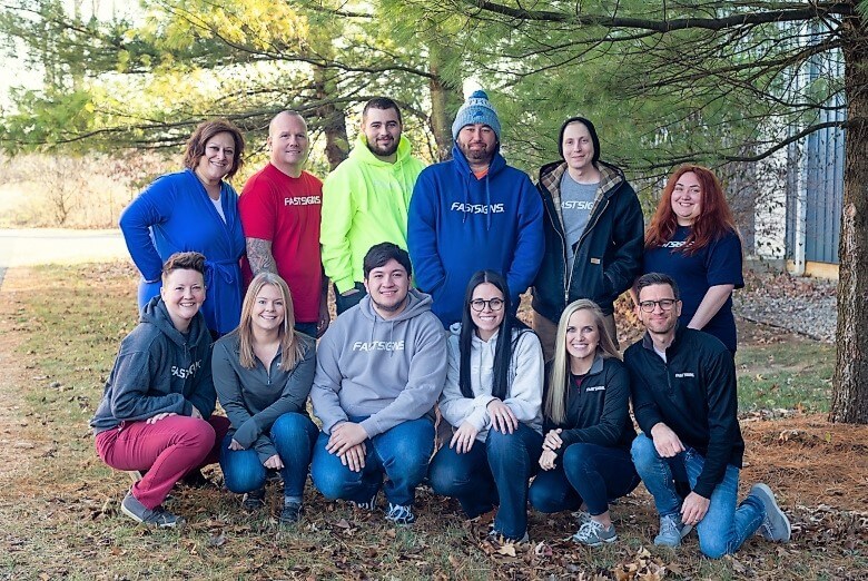 The team at FASTSIGNS of Toledo pose outside the store
