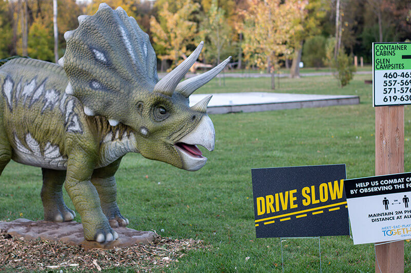 Drive slow sign with dinosaur statue