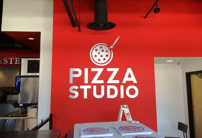 pizza studio logo on a wall