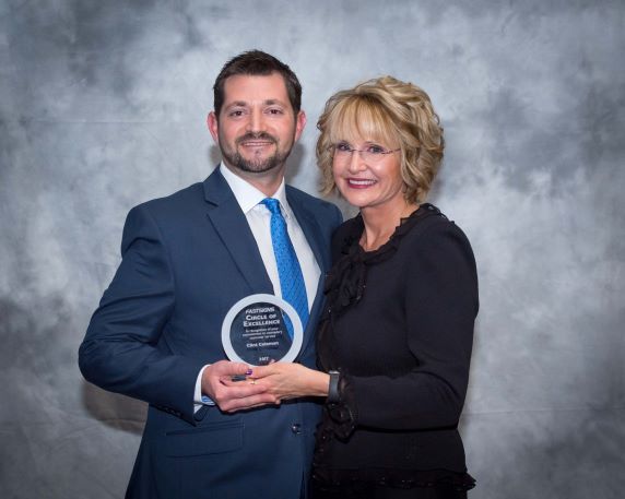 man and woman holding an award.