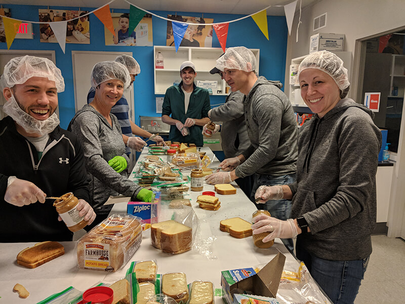 FASTSIGNS® of Grand Rapids, MI volunteering to make sandwiches for children in need